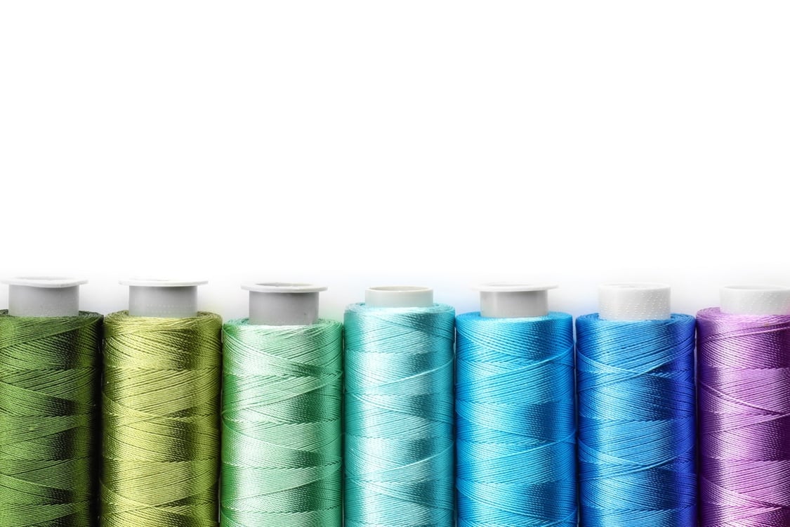reels of sewing thread in greens and blues